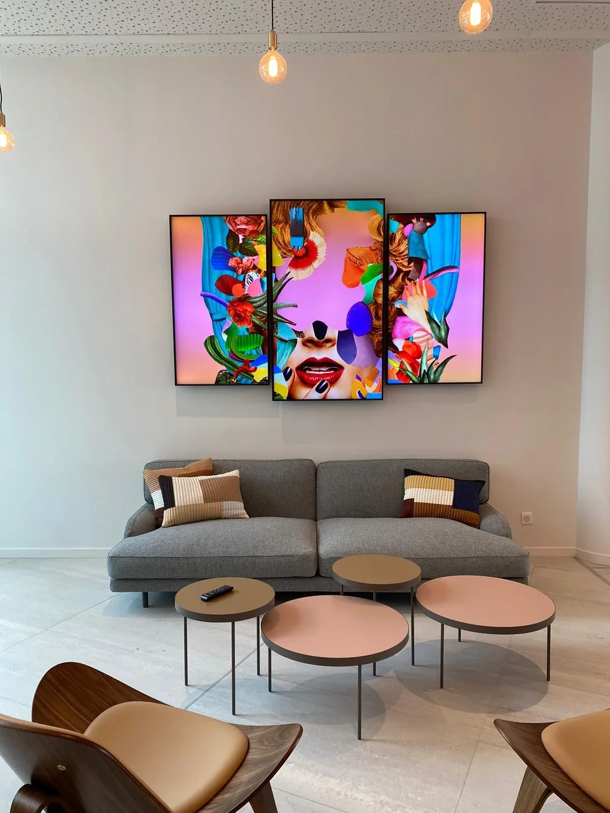 Corporate digital signage: three portrait screens on a lounge wall above sofas