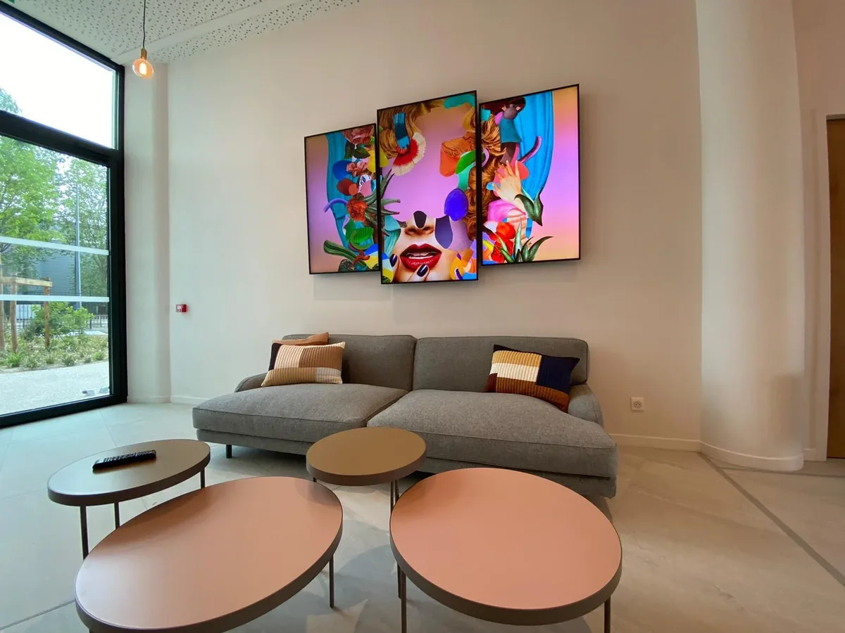 Three portrait displays above lobby seating